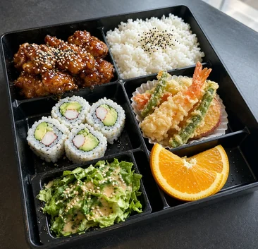 Bento box with rice, glazed chicken, California roll, shrimp and vegetable tempura, salad and orange slices